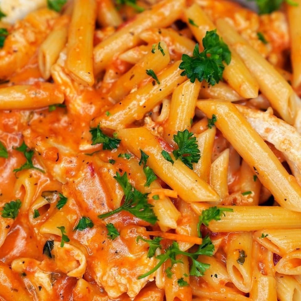 Penne pasta with creamy orange sauce, chicken, and fresh parsley from Jimmy's Grand Cafe.